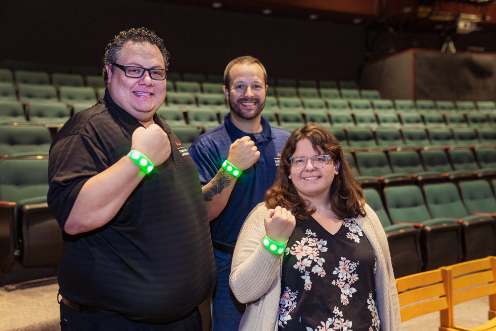 From left: Christopher Treviño, Alex Lorrain-Hill and Shelby Hibbs of UT Dallas show off the light-emitting diode wristbands that will be featured in the University’s upcoming production of “The Rocky Horror Show.” Hibbs, show director and clinical assistant professor in the School of Arts and Humanities, helped raise money to pay for the wristbands through Impact UTD. 
