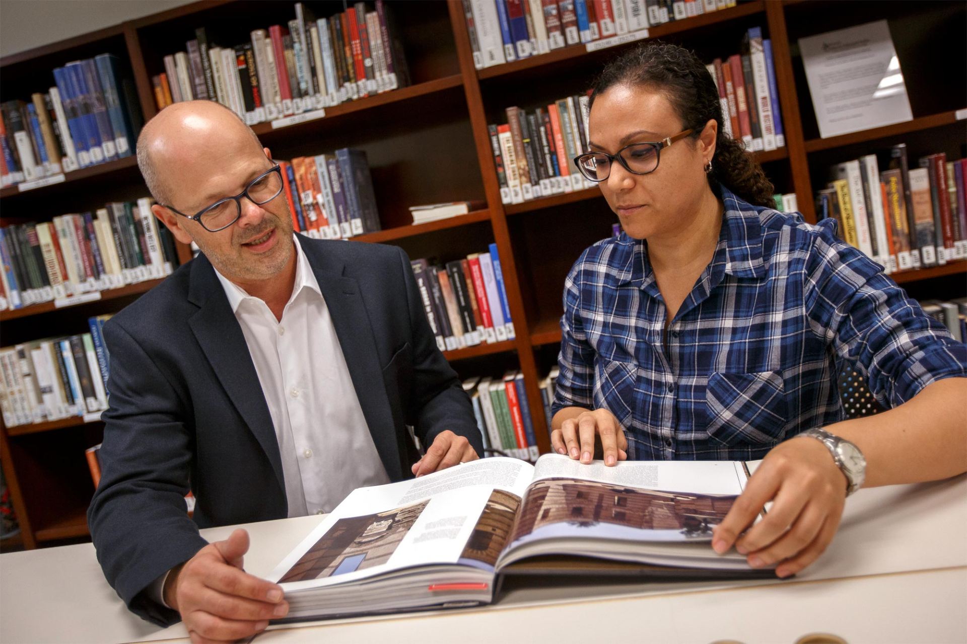 Dean Roemer and a student looking at a book