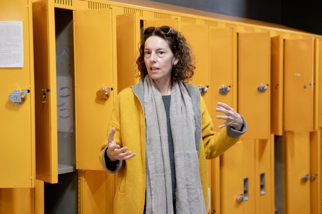 Professor xtine burrough addressing the HONS 3199 class in front of the lockers during the 2024 ATEC Pop-up Locker Exhibition unveiling. 