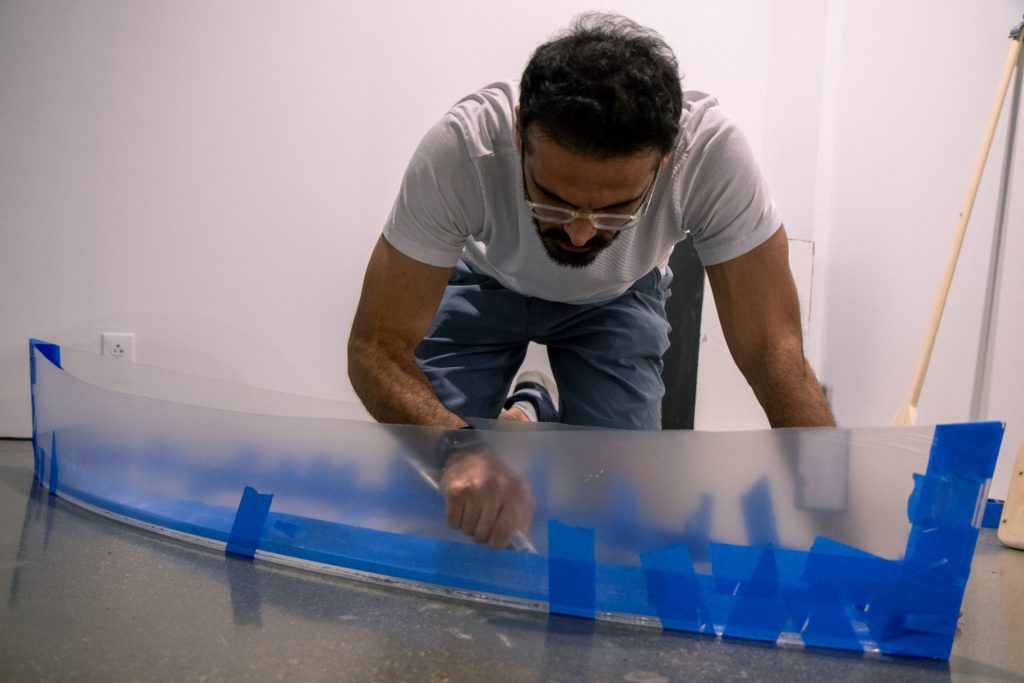 A graduate student is building a boat out of plexiglass as part of his installment. 